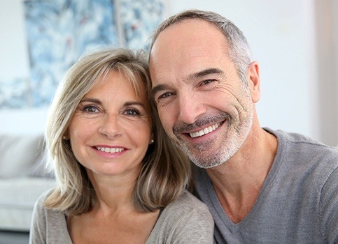 Smiling older man and woman after dental implant placement
