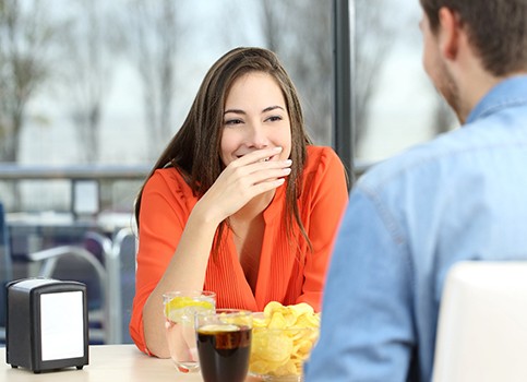 Woman hiding her smile while on a date