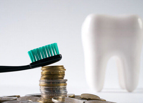 tooth next to a pile of coins