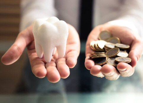 tooth balanced with a pile of coins