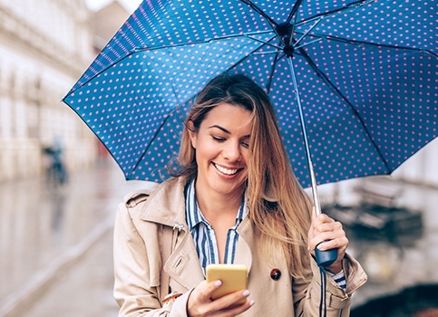 Woman smiling holding an umbrella
