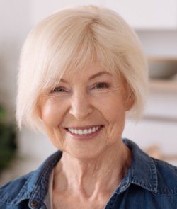 Older woman smiling after replacing missing teeth