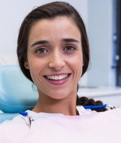 Woman smiling in dental chair during orthodontics treatment