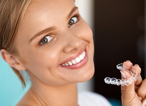 Woman placing Invisalign tray