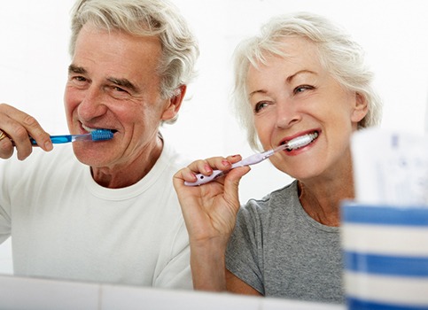 couple brushing teeth together in bathroom