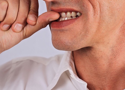 man biting his fingernails