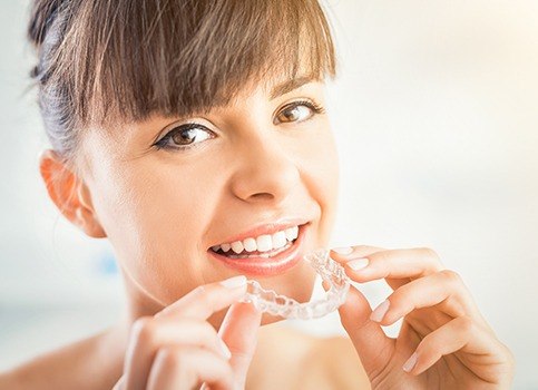 Woman placing Invisalign tray