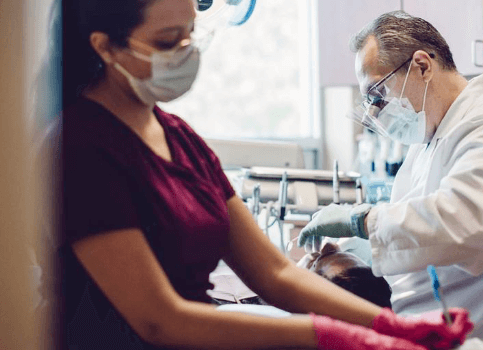 Dentist and team member treating dental patient