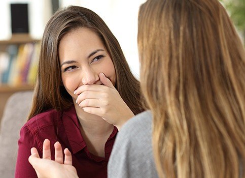 Woman covering her mouth before porcelain veneer placement