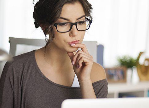 Woman considering porcelain veneers researching online