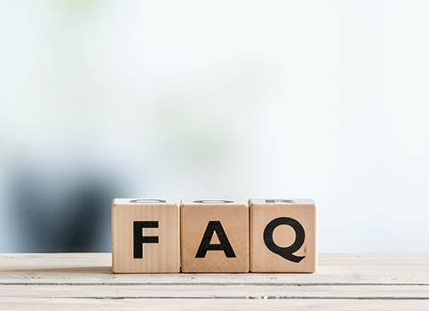 Three wooden letter blocks spelling FAQ on ledge