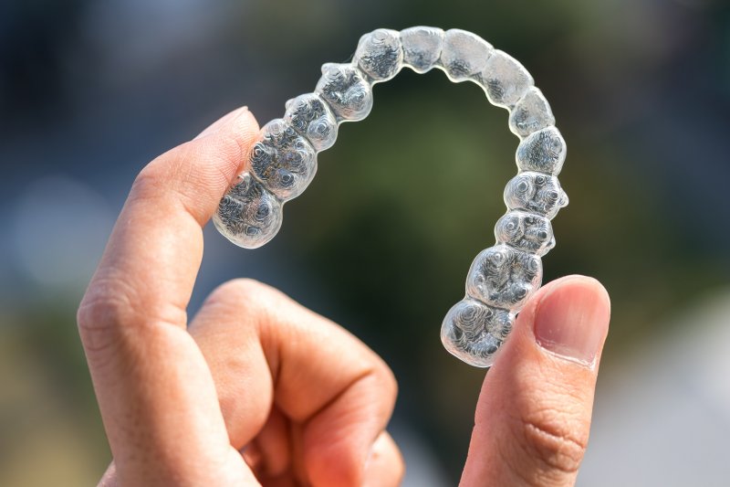 person holding Invisalign aligner