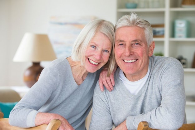 Older couple with dental implants smiling.