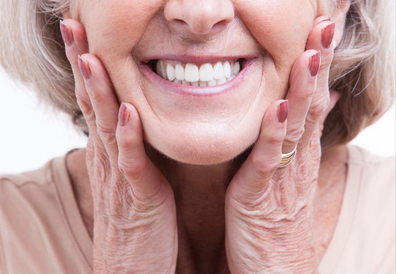 woman smiling after getting dentures in Sunnyside