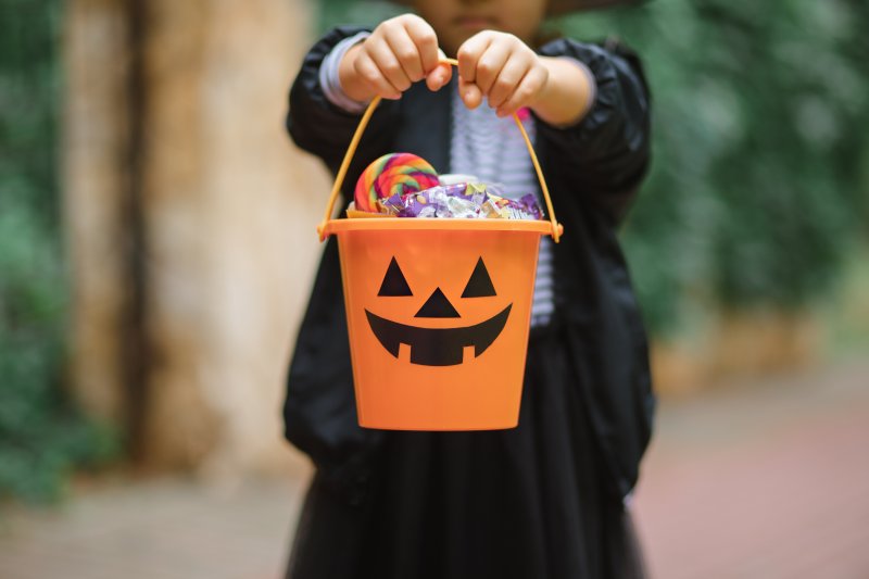 child holding up Halloween candy
