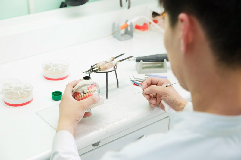 A lab technician working on dentures